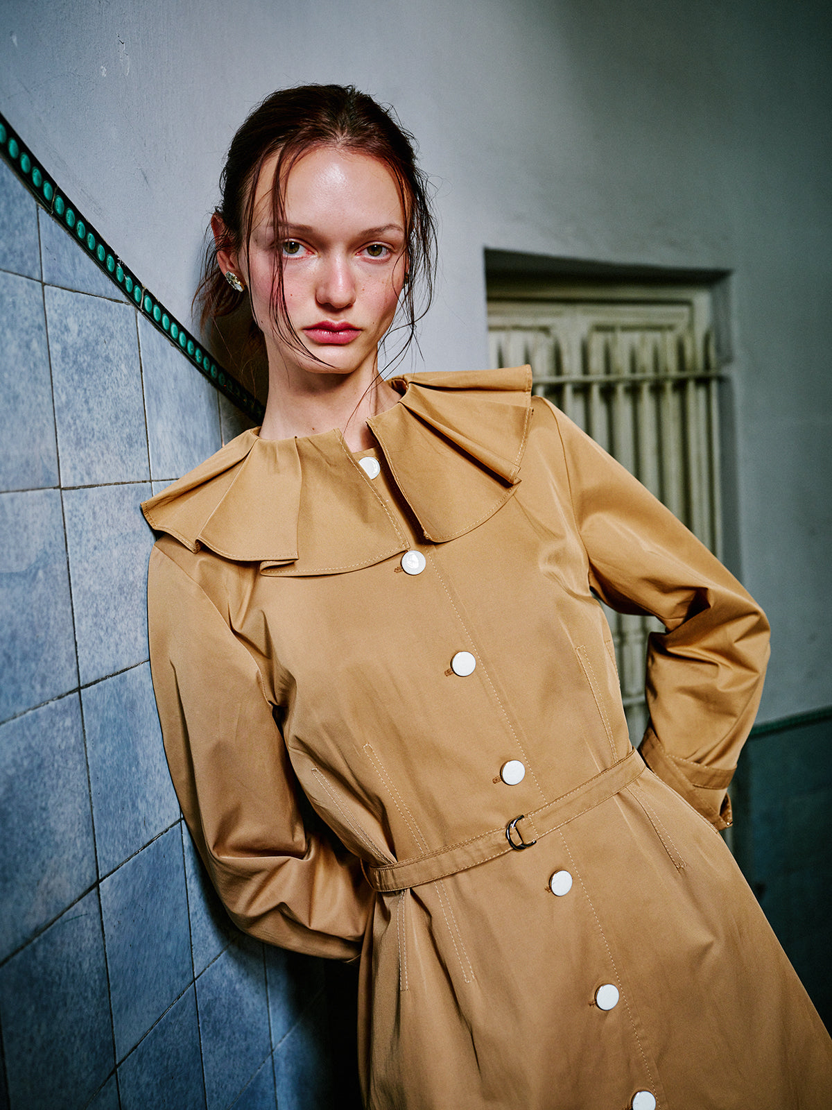 Modelin üzerinde WAYT Renaissance Memories bej trençkotun kanun pileli yaka detayı ve yapılandırılmış formu yakından görünüm.