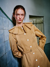 Load image into Gallery viewer, Modelin üzerinde WAYT Renaissance Memories bej trençkotun kanun pileli yaka detayı ve yapılandırılmış formu yakından görünüm.