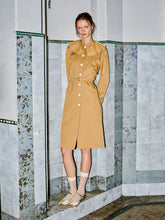 Load image into Gallery viewer, Modelin üzerinde WAYT tasarımı Renaissance Memories bej trençkot, pileli yaka ve korsaj görünümlü kesimiyle modern bir silüet sunuyor.